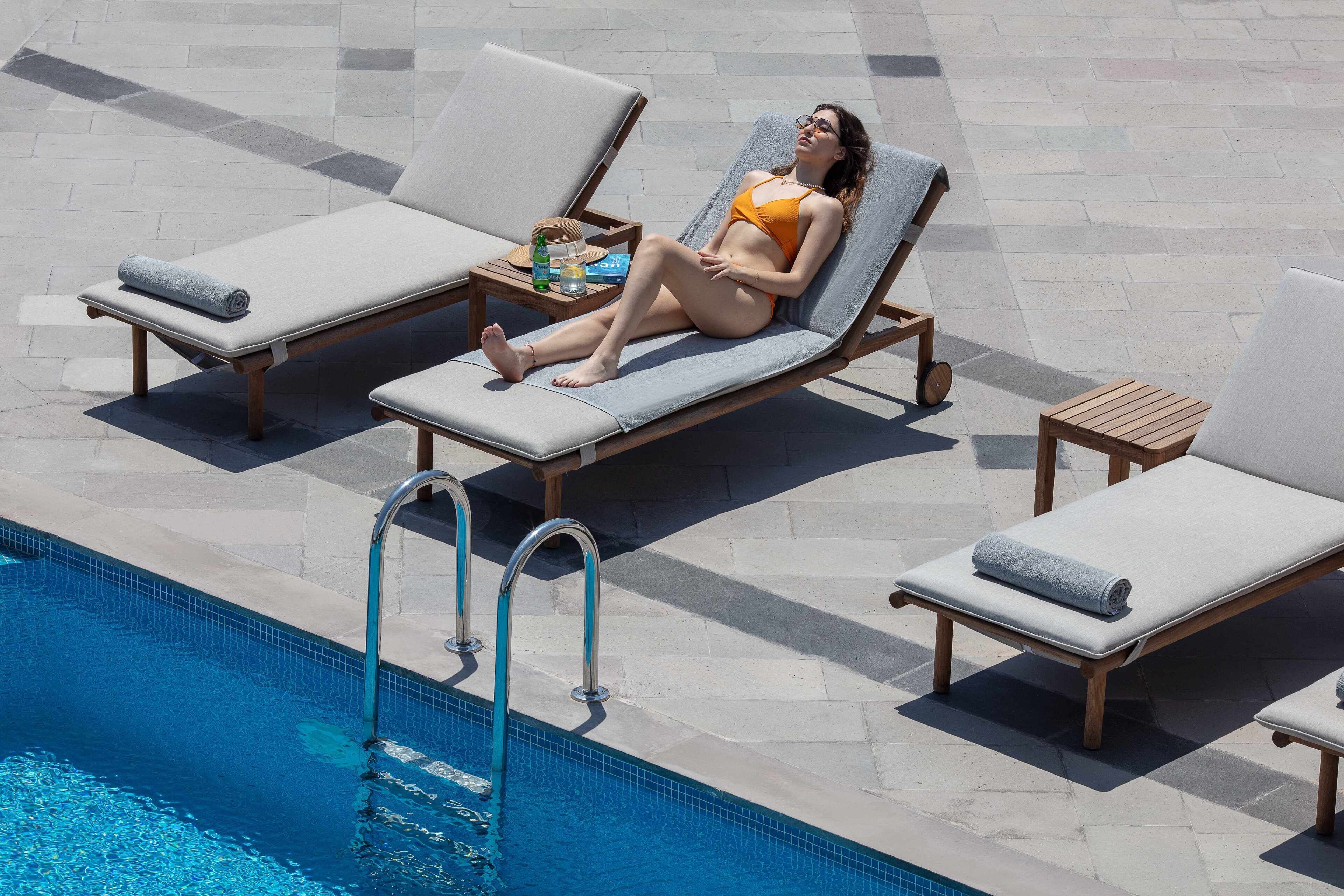 A poolside area with lounge chairs and a pool.