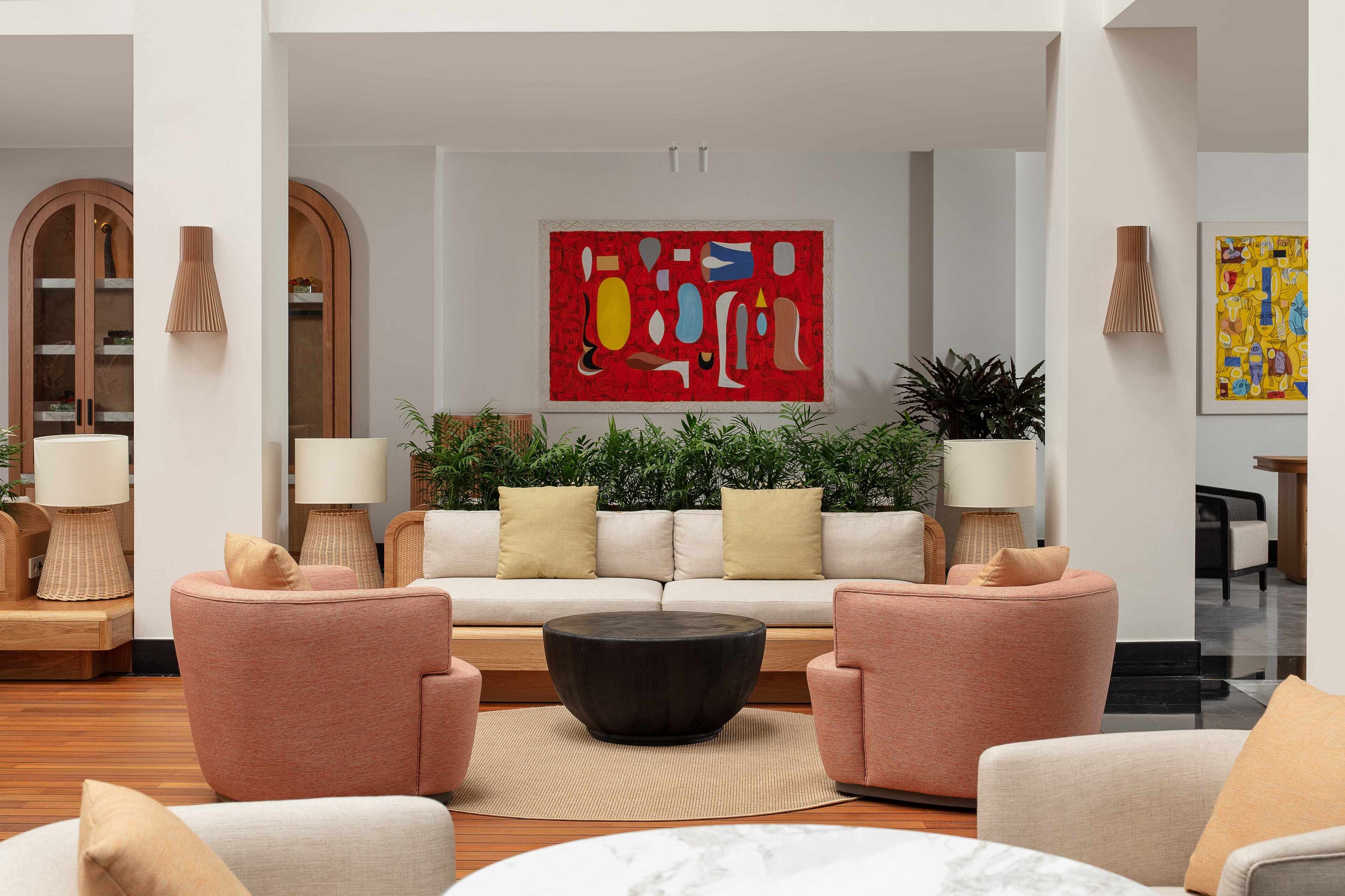 A modern living room with a sofa, armchairs, a coffee table, and decorative lamps.