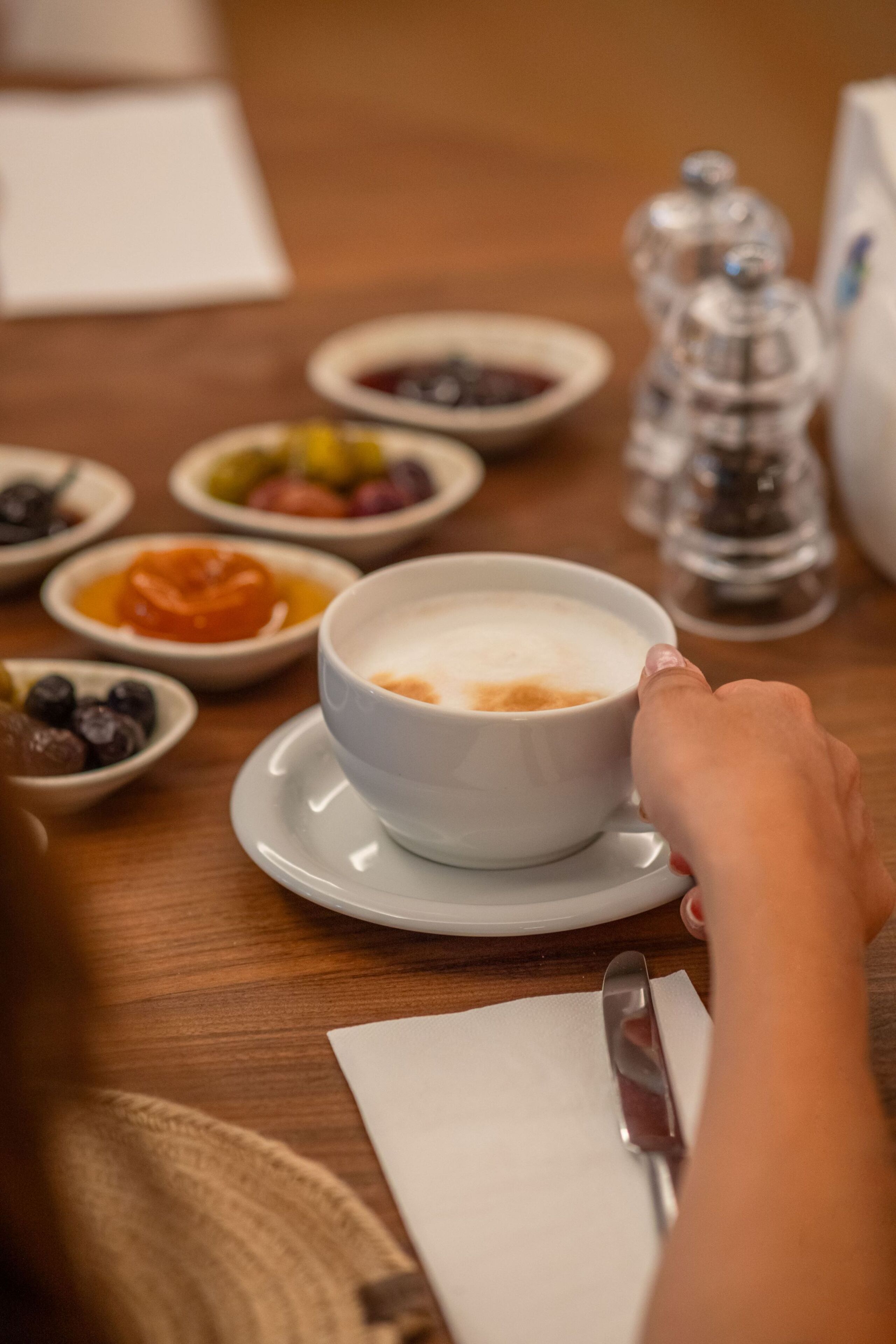 A breakfast setting with a bowl of cereal and various fruits on a wooden table.