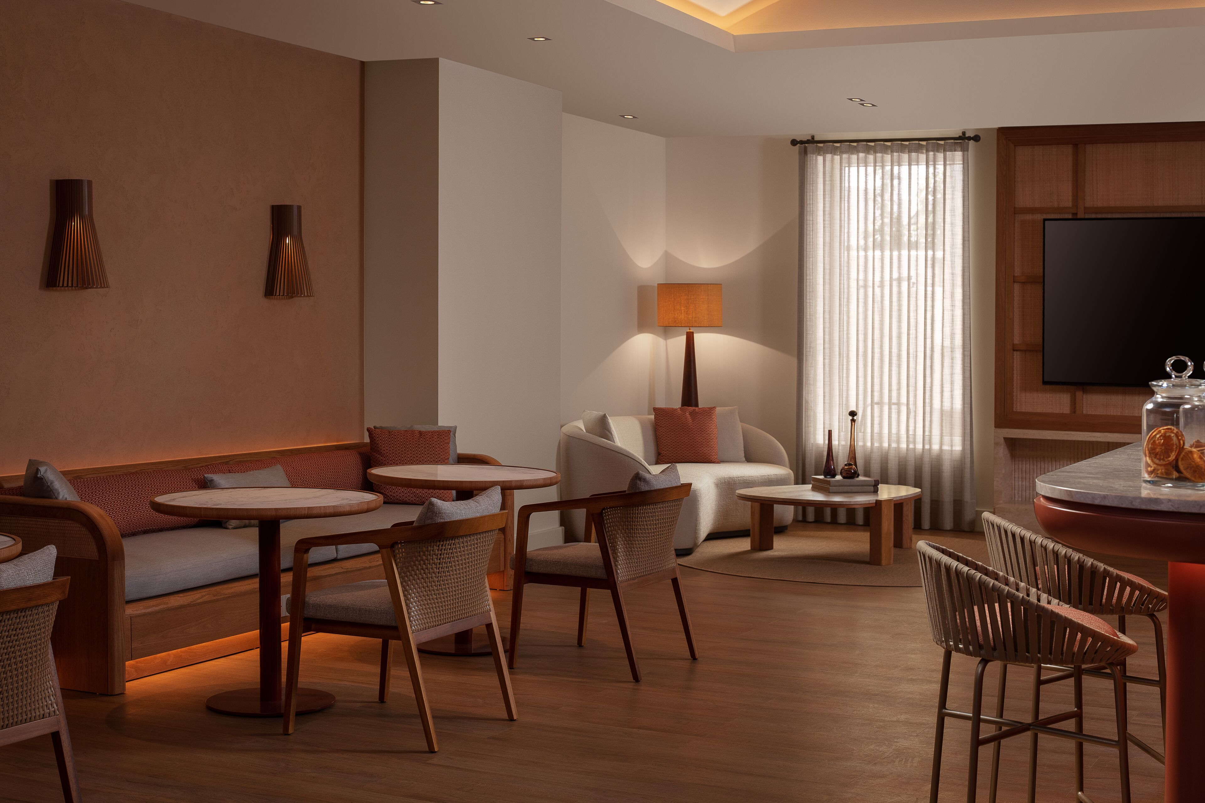 A modern living room with a sofa, chairs, a coffee table, a lamp, and a flat-screen TV.