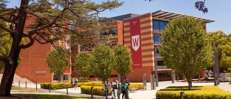 A modern building with a prominent 'W' logo, surrounded by well-maintained landscaping and trees.