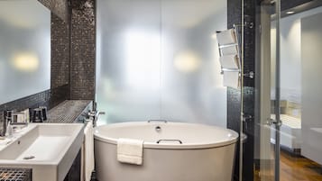 A modern bathroom with a freestanding bathtub, a large sink, and a glass shower enclosure.