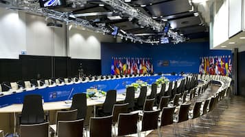 Ein Konferenzraum mit langem Tisch, Stühlen und einer Wand mit Flaggen.