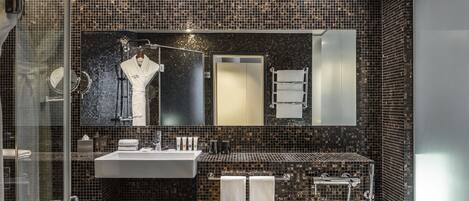 Un baño moderno con cabina de ducha de vidrio, un espejo grande, un lavabo blanco y una bañera.