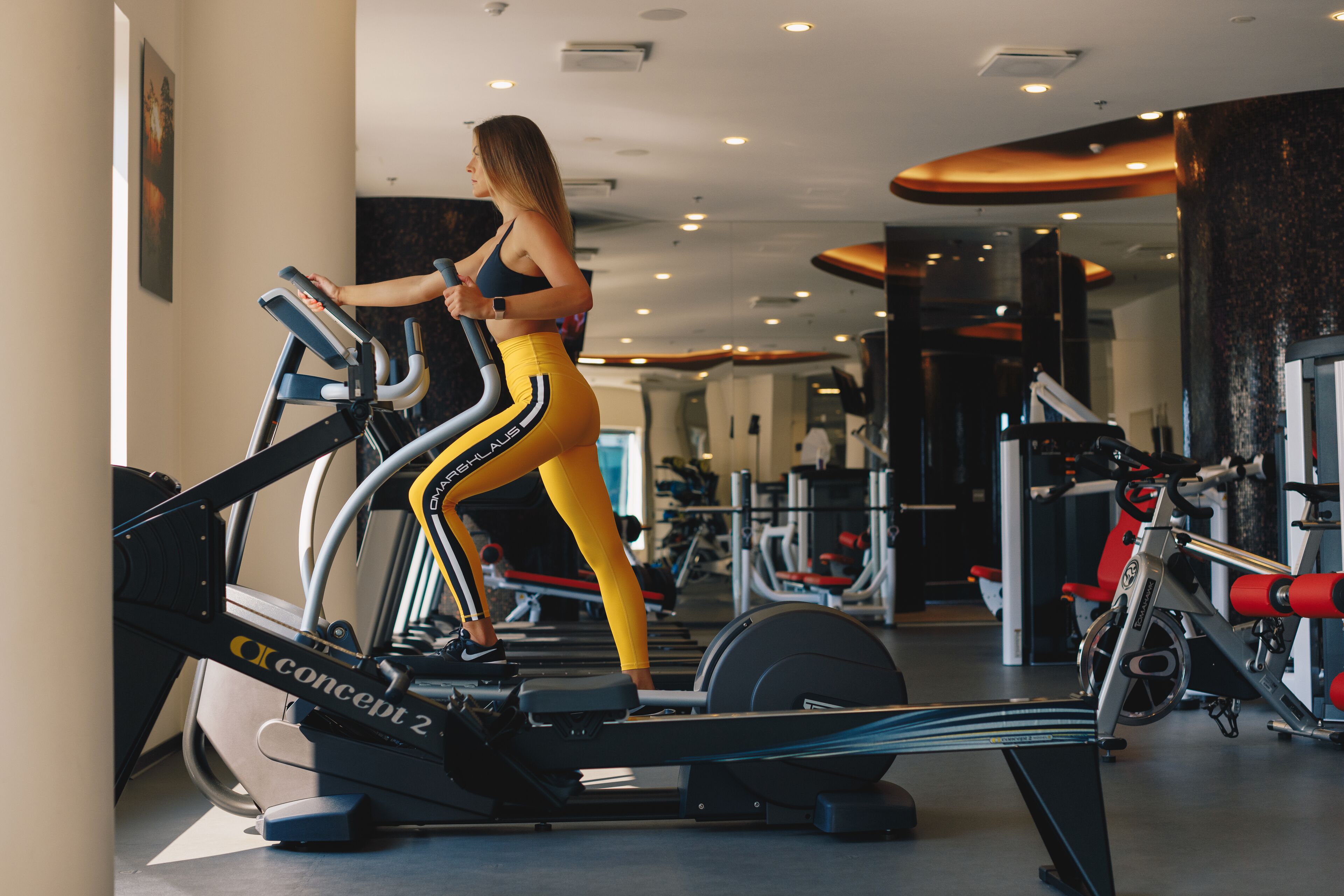 A gym with stationary bikes, weight machines, and a mirror.