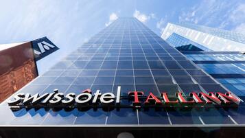 La façade extérieure de l’hôtel Swissotel Falls offre une vue dégagée sur son élégante façade en verre et met en valeur le nom de l’hôtel.