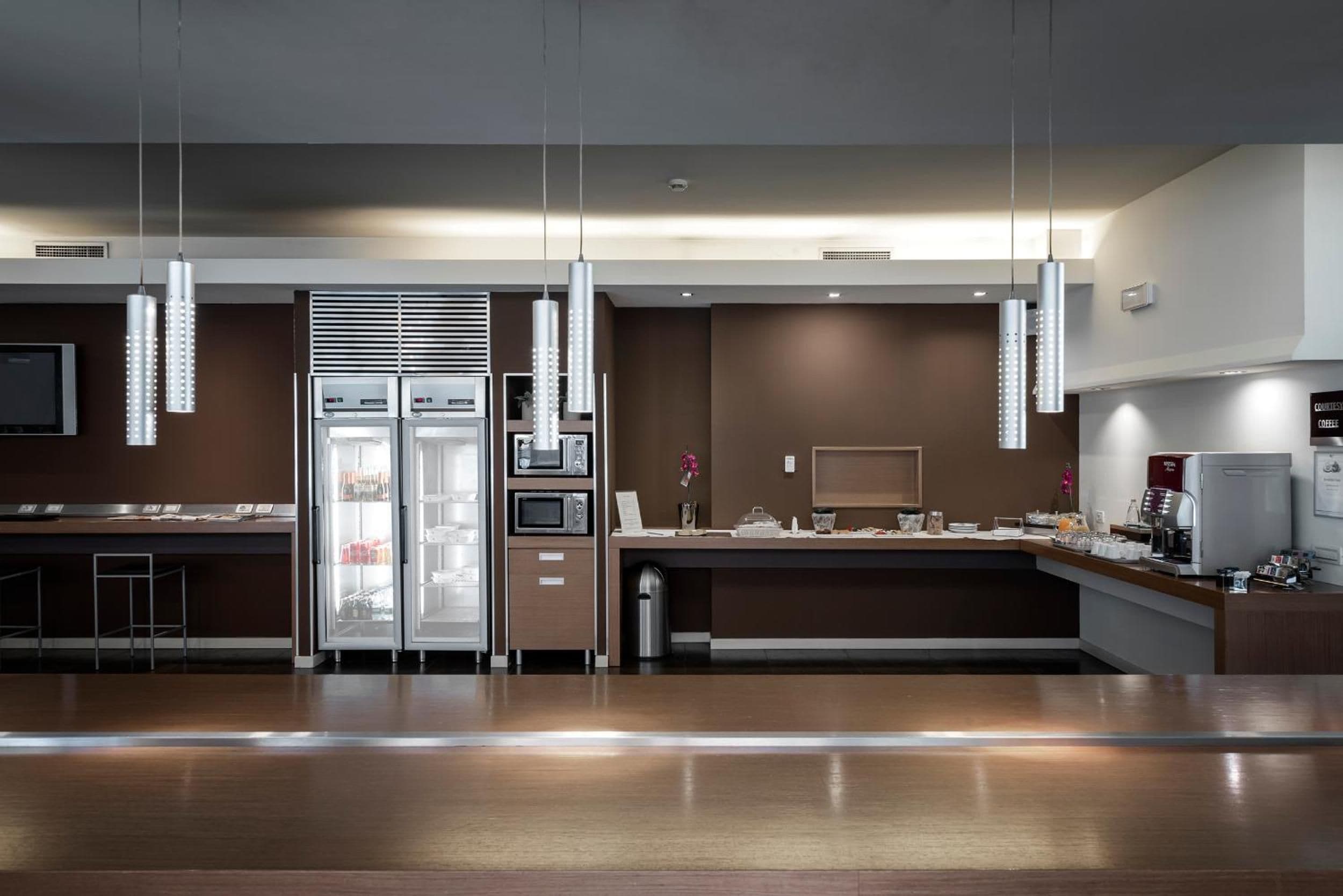Eine moderne Küche mit Edelstahlgeräten, einem Kühlschrank, einer Mikrowelle und einer Kaffeemaschine.