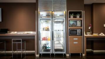 A modern kitchen with a built-in refrigerator, microwave, and a small bar area.