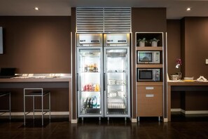 A modern kitchen with a built-in refrigerator, microwave, and a small bar area. - Hc3 Hotel (Bologna)