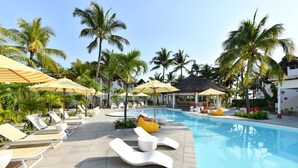 A poolside area with lounge chairs and umbrellas, surrounded by palm trees. - Veranda Belle Mare - All Inclusive (Belle Mare)