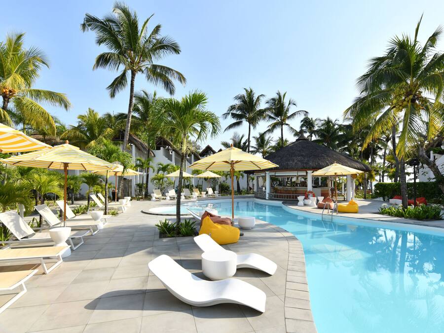 Een buitenzwembad, parasols bij het zwembad en ligstoelen