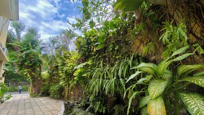 A paved pathway, lush greenery, and a building facade. - Bali Emerald Villas (Denpasar)