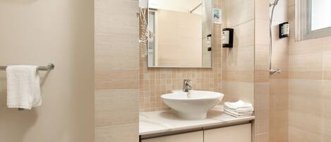 A bathroom with a sink, mirror, towel rack, and shower.