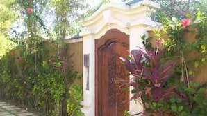 A pathway leading to a building with a decorative entrance. - Bali Jade Villas (Denpasar)