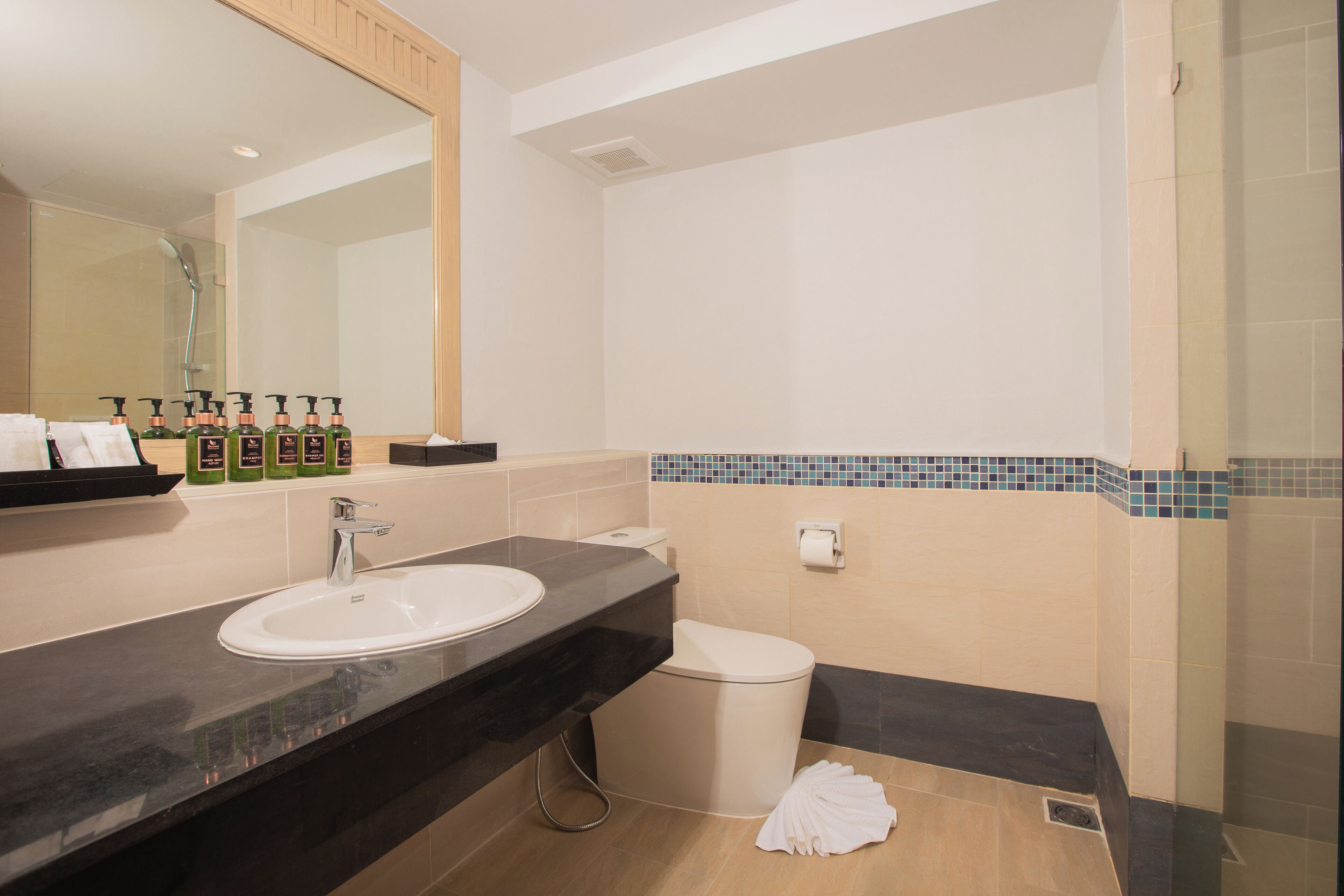 A modern bathroom with a sink, mirror, and toiletries.