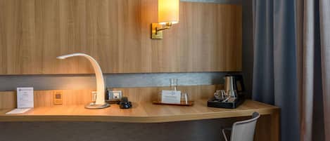 A hotel reception desk with a modern lamp, a coffee machine, and a glass display.