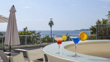 Enjoy a refreshing drink on this ocean-view terrace with a shaded table.
