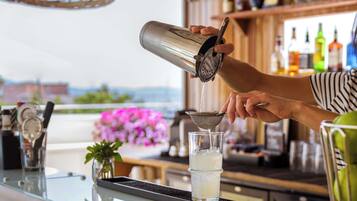 A bartender pouring a drink into a glass.