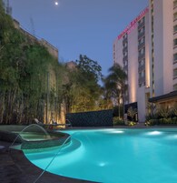 Una piscina con vista despejada del hotel Victoria Ejeutivo al fondo.