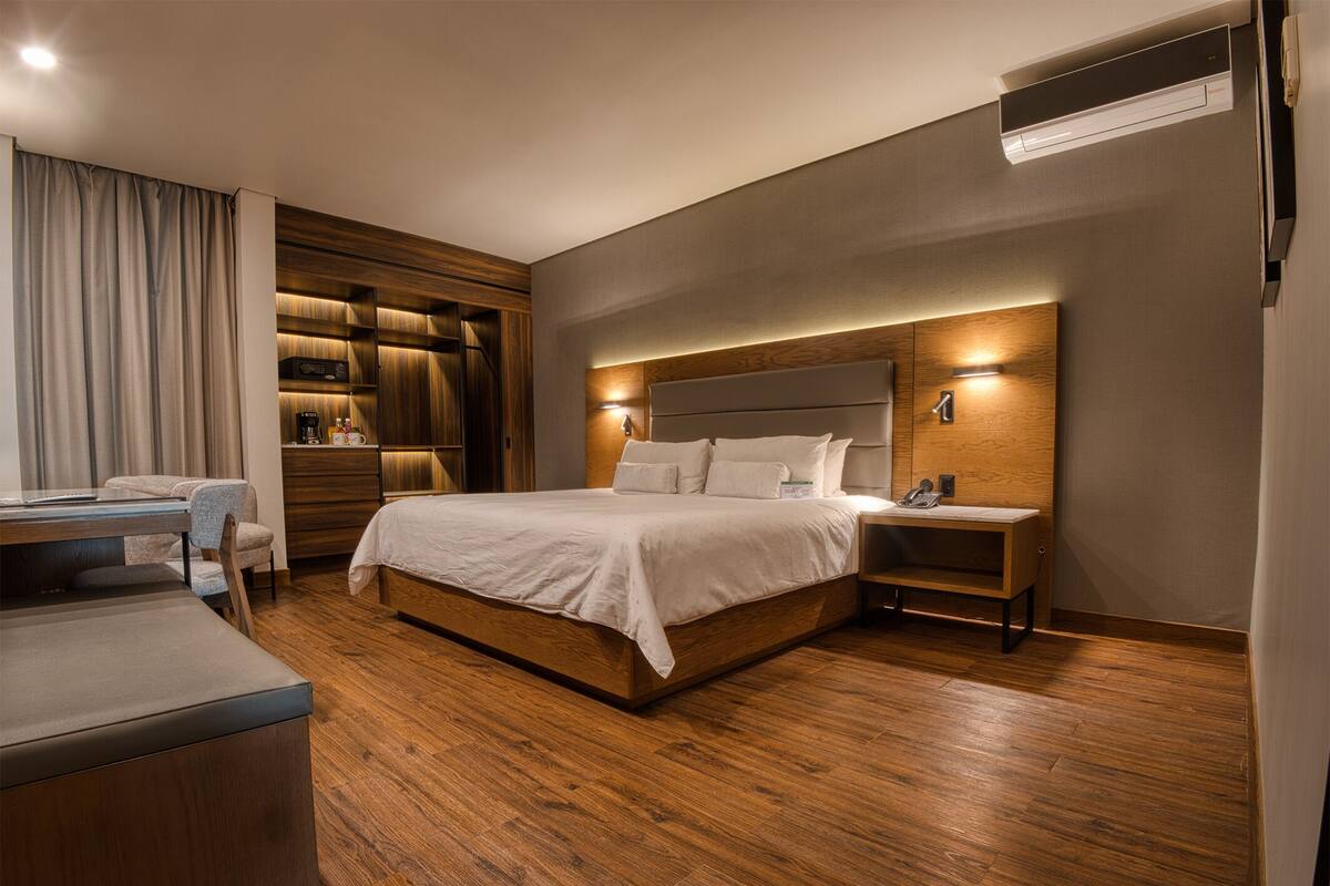 Une chambre d’hôtel moderne dotée d’un grand lit, d’un bureau et d’une armoire intégrée.