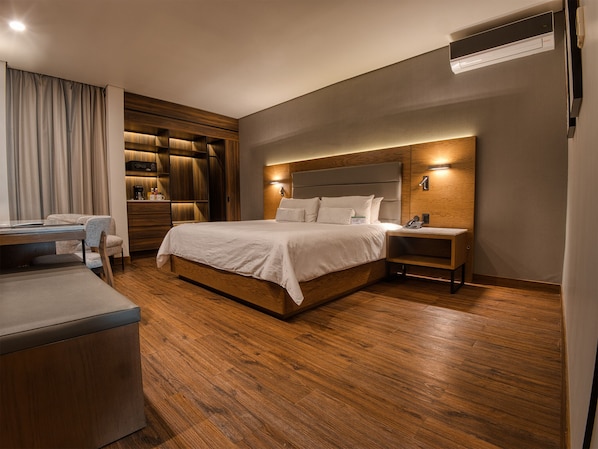 Una habitación de hotel moderna con una cama grande, un escritorio y un armario empotrado.