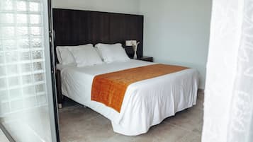 A bedroom with a bed, a nightstand, and a window.