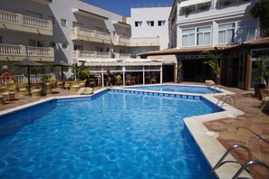 Una piscina al aire libre, sombrillas