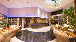 A spacious lobby with a reception desk, comfortable seating areas, and a large plant. - Alba Seleqtta (Lloret de Mar)