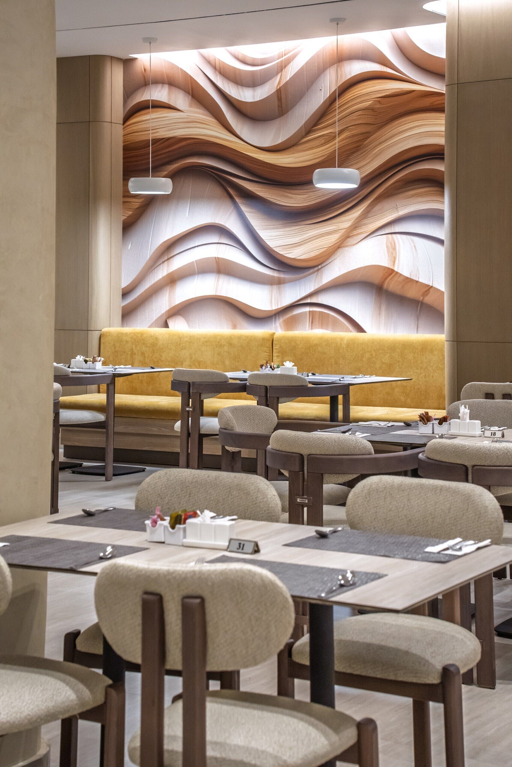 Een modern restaurantinterieur met een opvallend golvend wandontwerp, zitmogelijkheden en gedekte tafels.