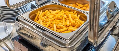 A buffet setup with a French fries container and a glass display case.