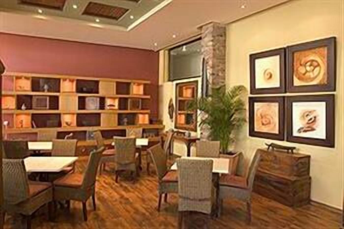 A library with bookshelves, chairs, and framed artwork on the walls.