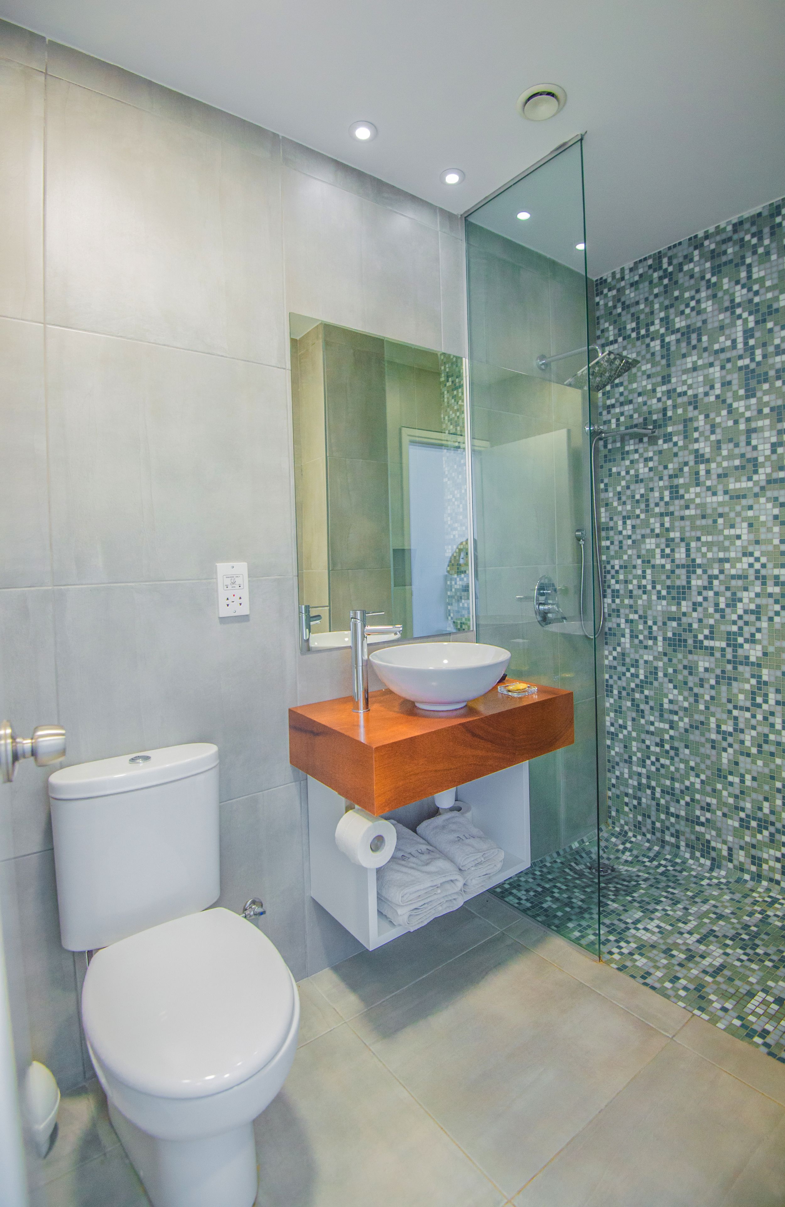 A modern bathroom with a toilet, sink, and shower.