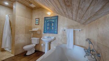 Ein Badezimmer mit Badewanne, Toilette, Waschbecken und Holzboden.