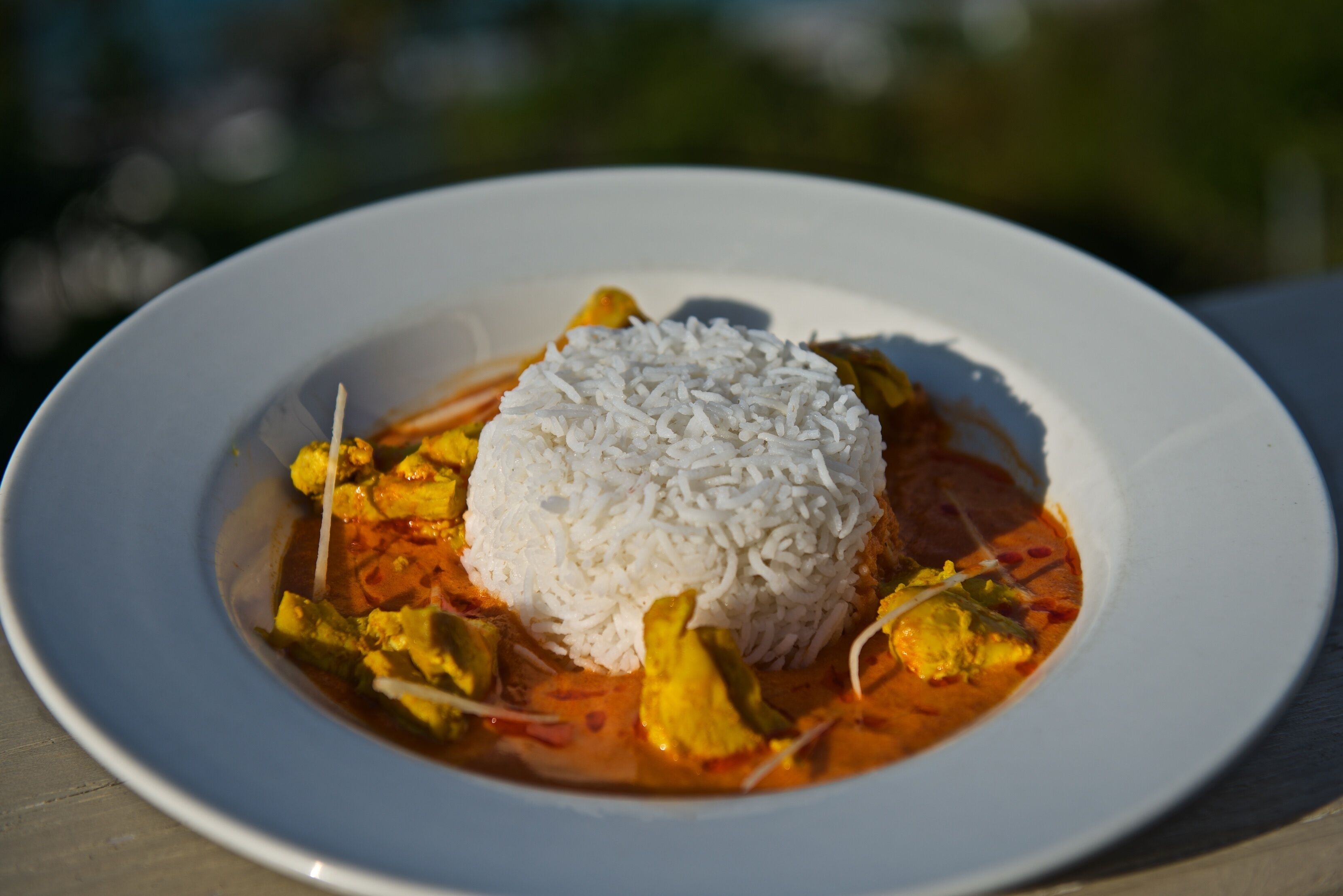 A plate of white rice and curry with vegetables.