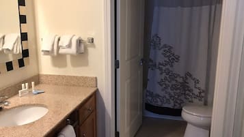A bathroom with a sink, mirror, towel rack, and toilet.