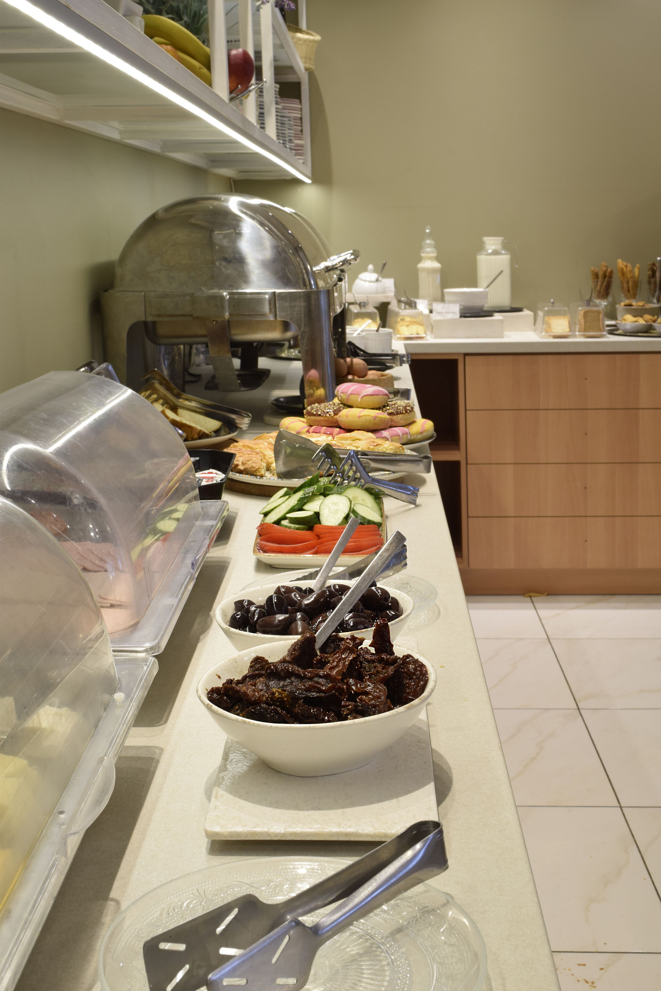 Montaje de bufé con diversos alimentos y utensilios de servicio.