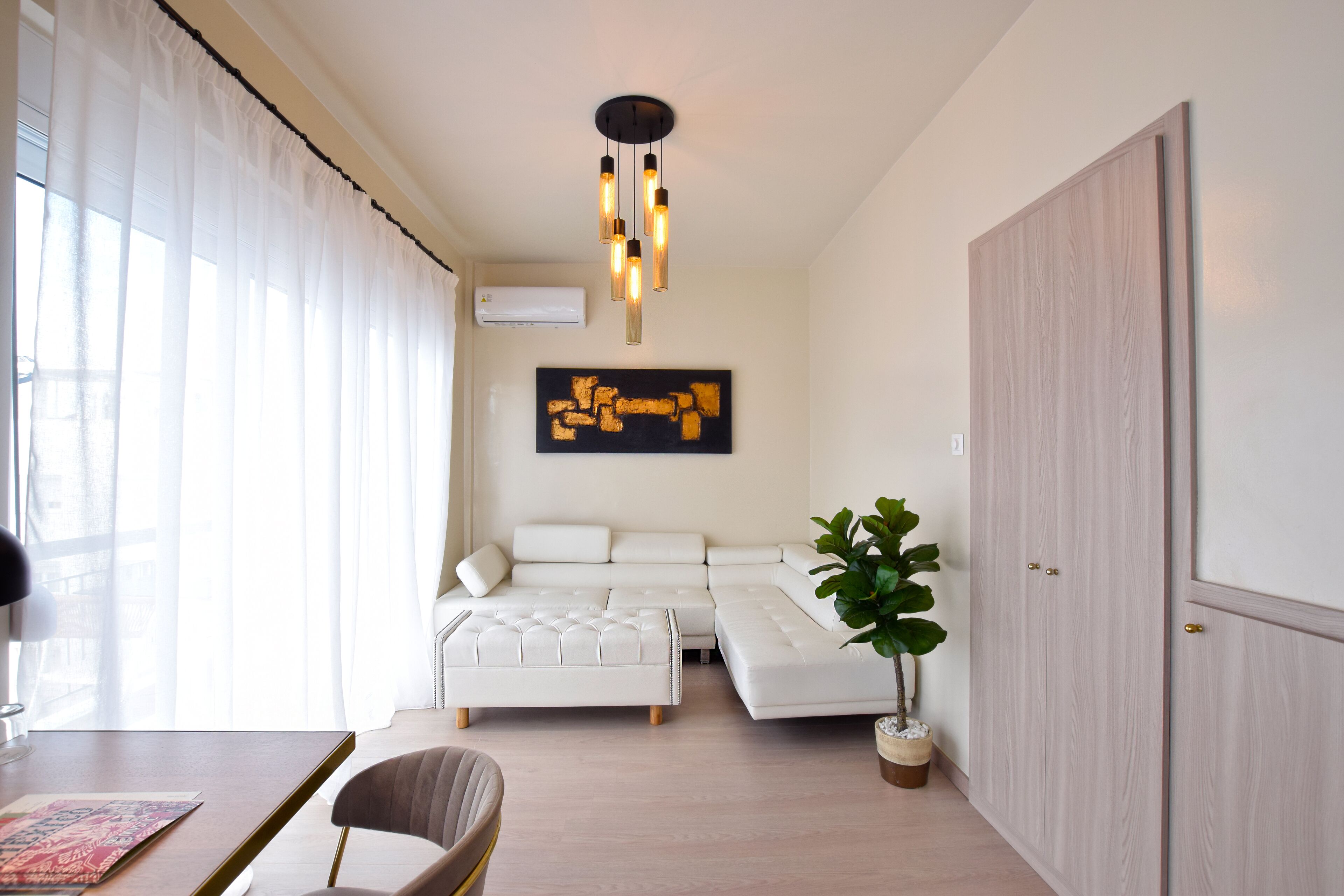 A modern living room with a sectional sofa, a coffee table, and a potted plant.