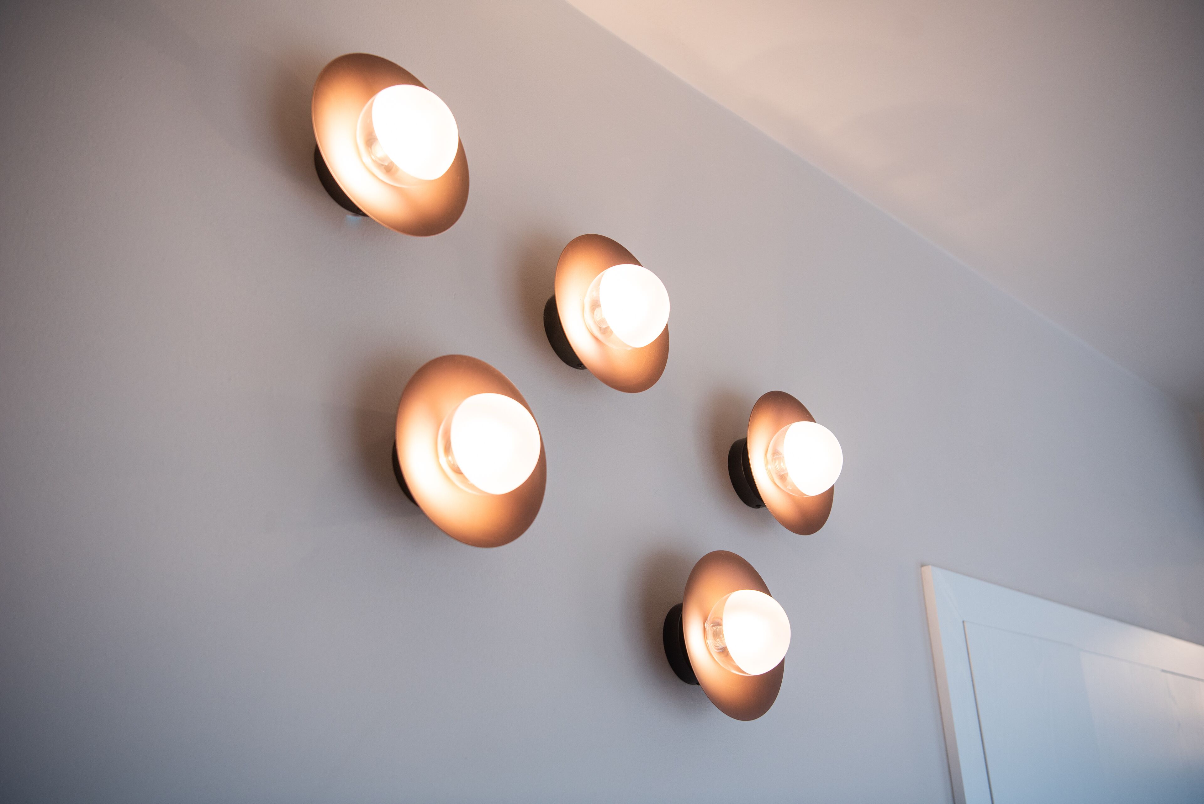 A ceiling with five wall-mounted light fixtures.