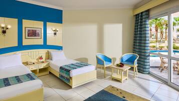 Habitación de hotel con dos camas, una mesita, dos sillas y vistas al área exterior.