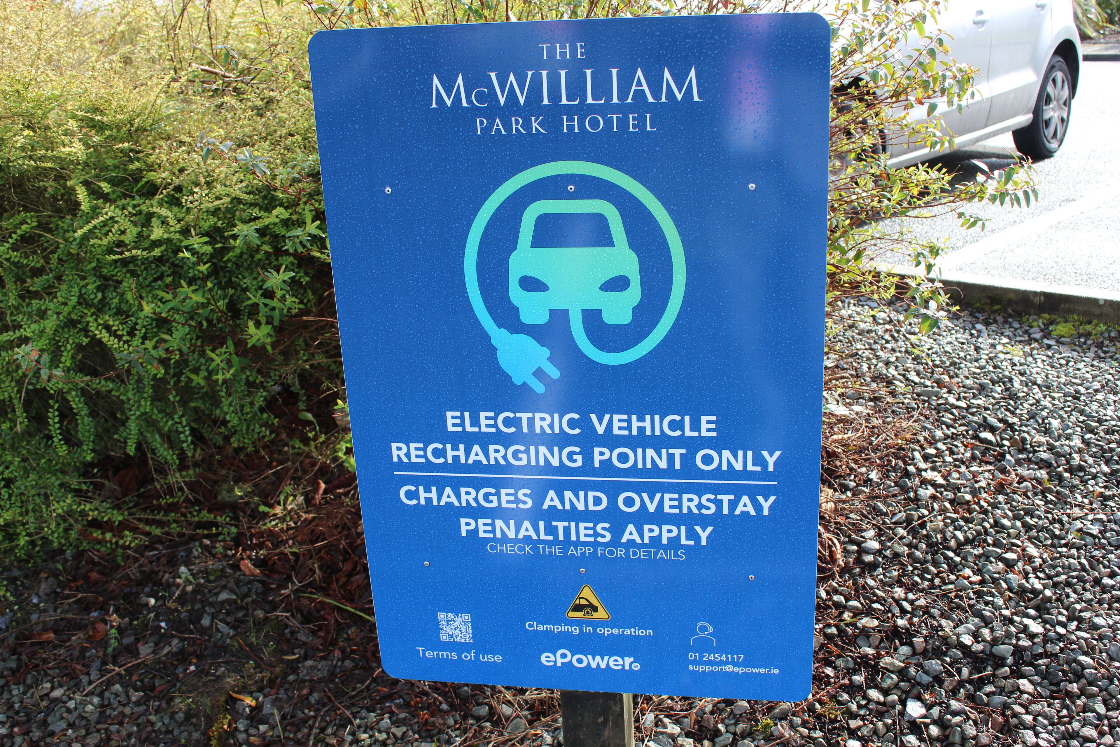 A sign for The McWilliam Park Hotel indicating an electric vehicle charging point.