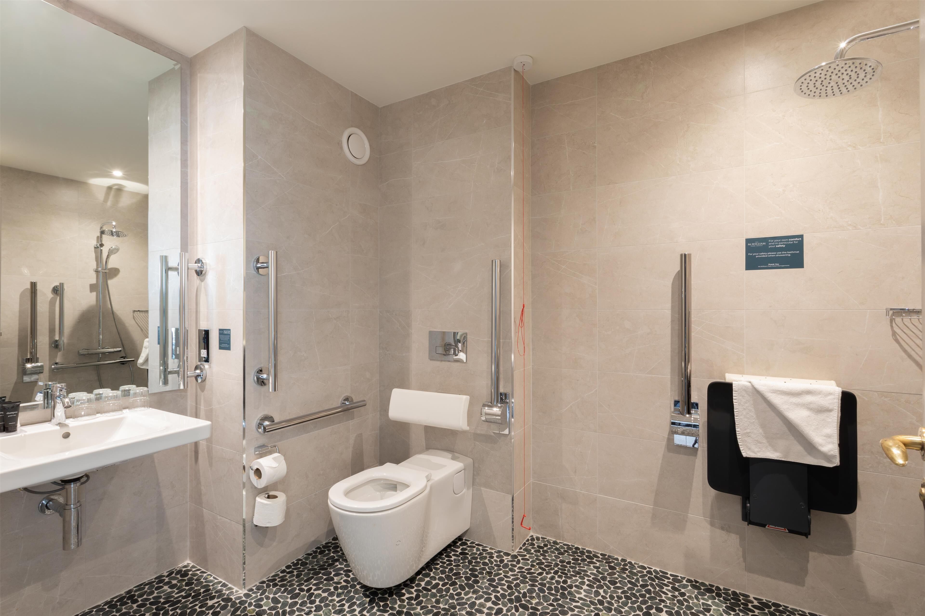 Un bagno moderno con doccia, servizi igienici e lavandino.