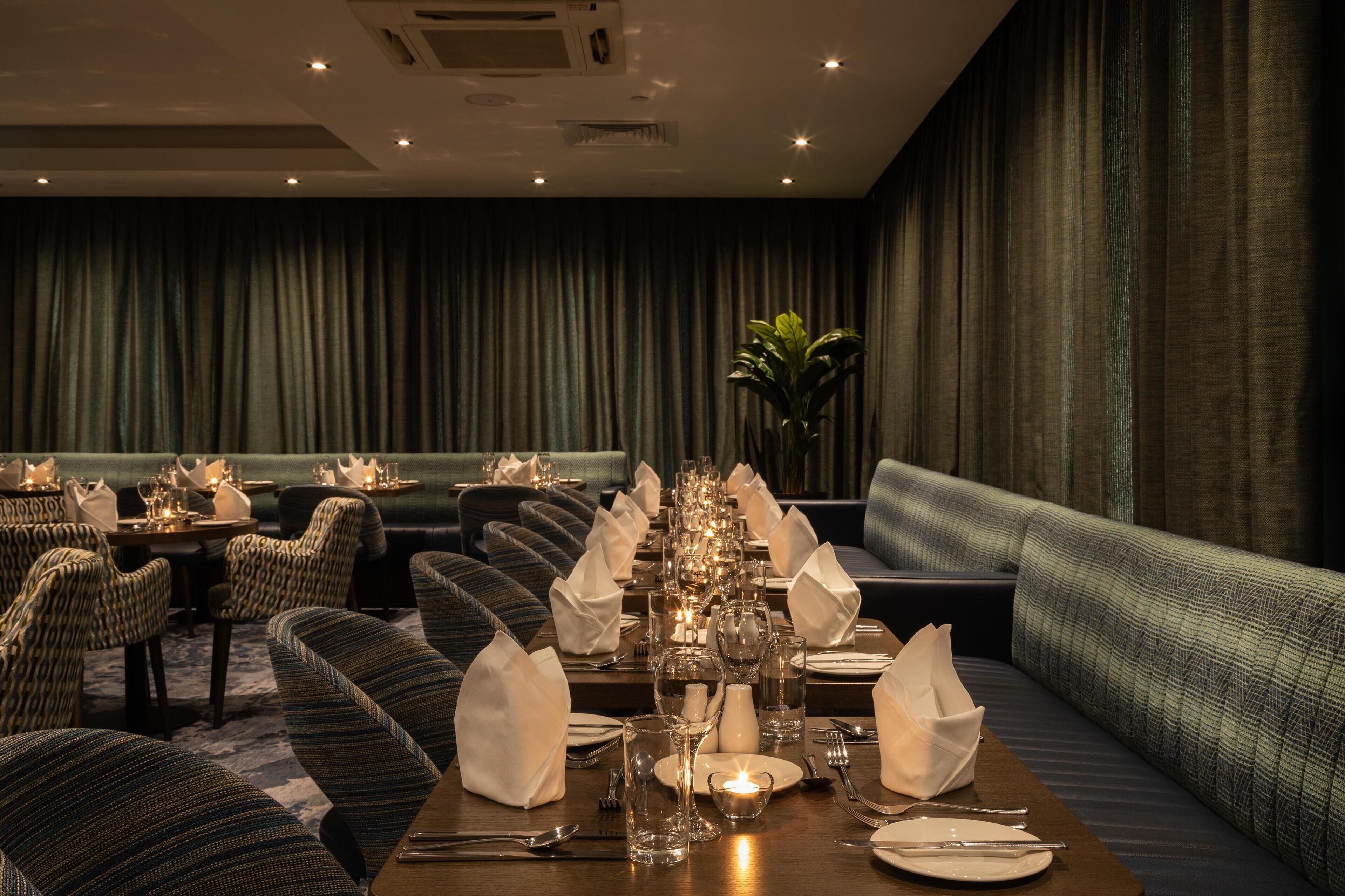 A dining area with tables set for a meal, including plates, glasses, and cutlery.