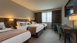 Een hotelkamer met twee bedden, een bureau, een stoel en een televisie.
