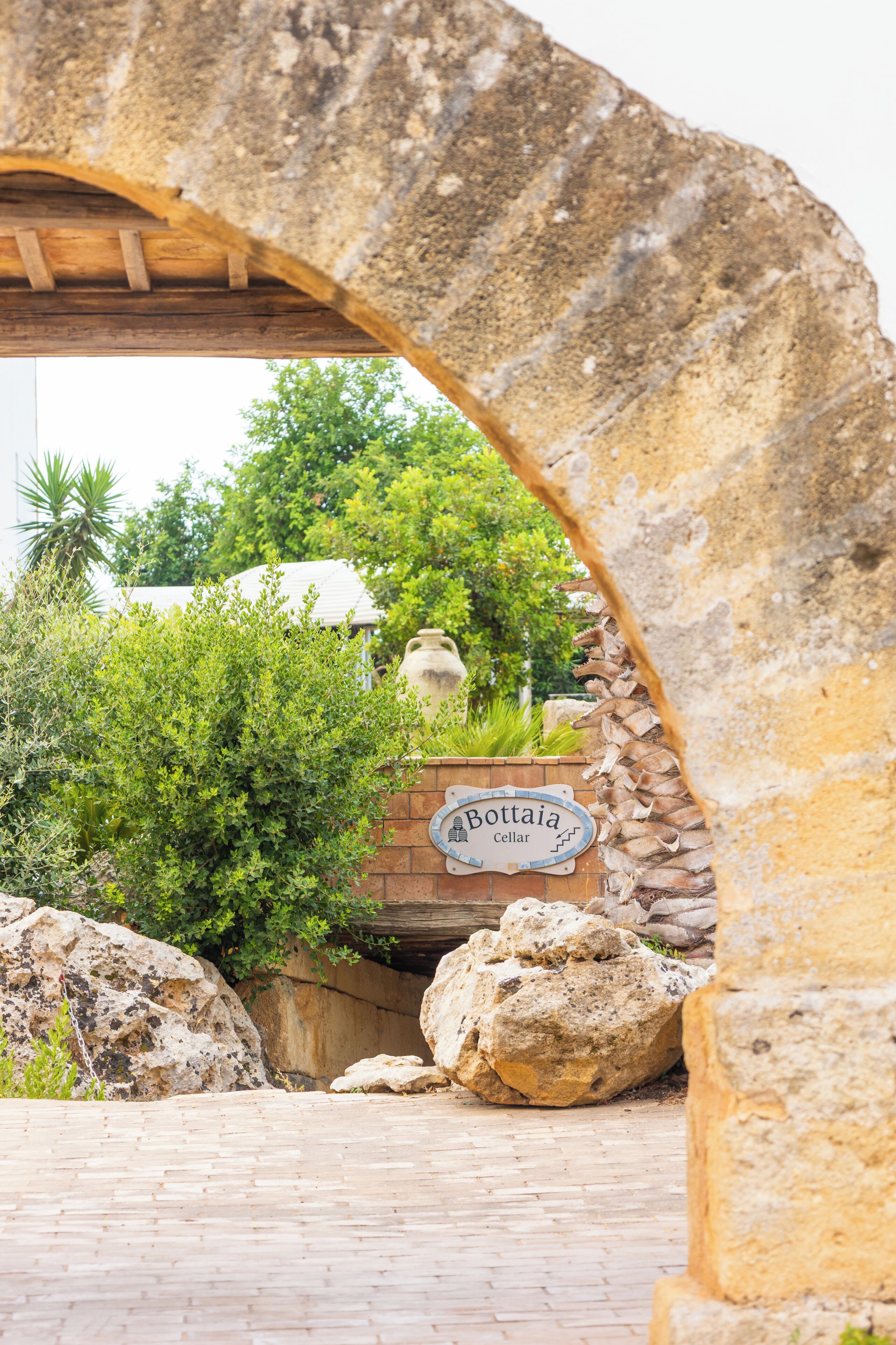 An arched stone structure with a sign reading 'Bottai Cellar'.