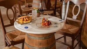 A table with a dessert plate, a glass of red wine, and a basket of pretzels. - Baglio Basile Hotel (Petrosino)