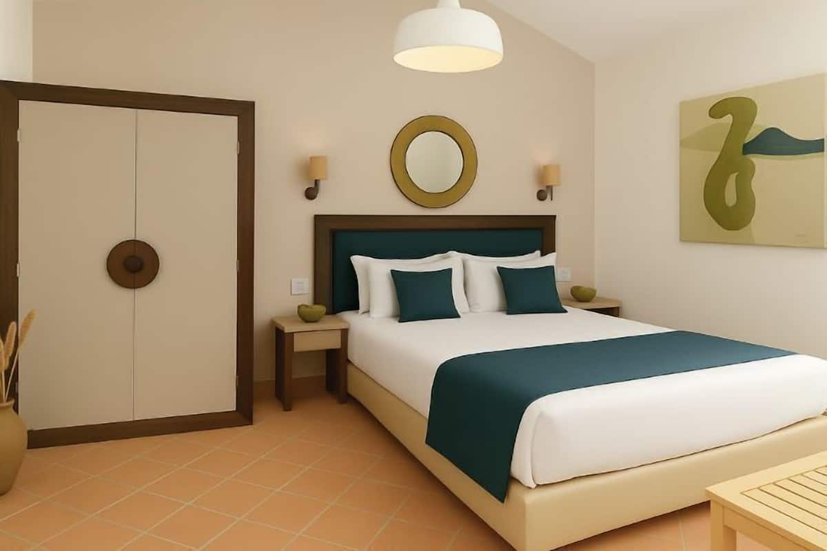 A hotel room with a bed, bedside tables, a mirror, a door, and a wall with a painting.