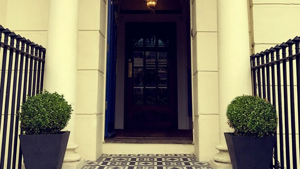 Der Eingang des Brighton House mit einer klassischen Fassade, nummerierten Säulen und einem gemusterten Boden.