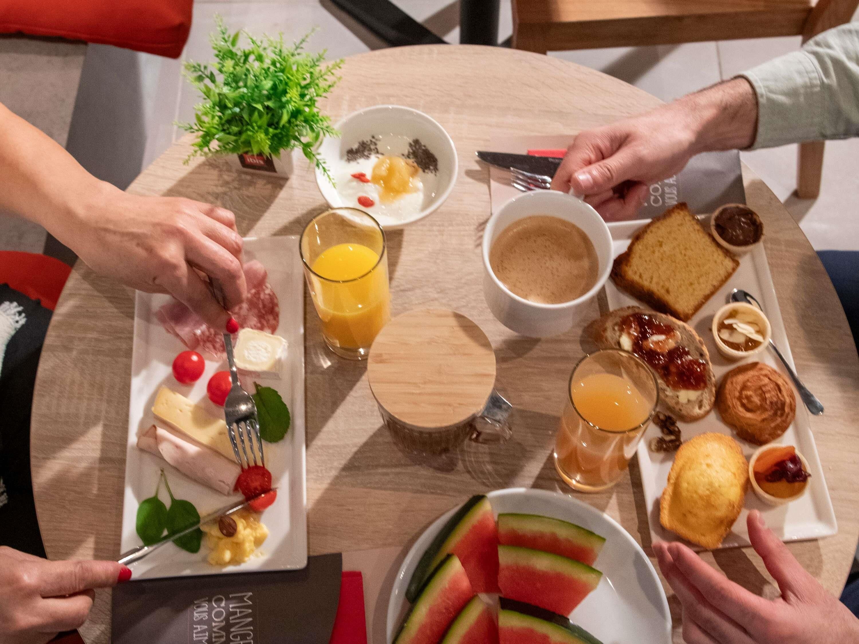 Una mesa redonda con diferentes alimentos y bebidas para el desayuno.