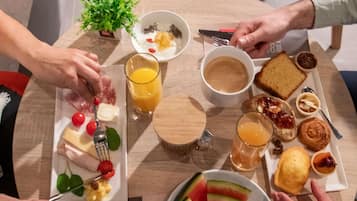 Una colazione con diversi cibi e bevande su un tavolo rotondo.