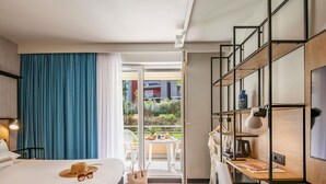 Ein Hotelzimmer mit Bett, Schreibtisch und Balkon.